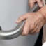 An older adult uses a grab bar representing one of the home modifications that is helpful for fall prevention for elderly adults.